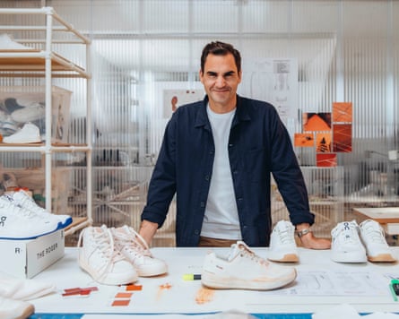 Roger Federer stands besides a table sporting all manner of trainers