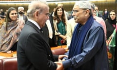 Shehbaz Sharif and Asif Ali Zardari shake hands in Pakistan's National Assembly, the lower house of parliament as people look on.