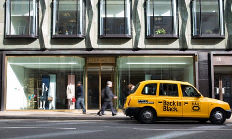 A yellow London taxi cab operated by Hailo stands outside store in 2014.