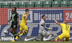 Dortmund’s Raphael Guerreiro, 2nd left, celebrates after scoring the opening goal past Wolfsburg’s goalkeeper Koen Casteels.