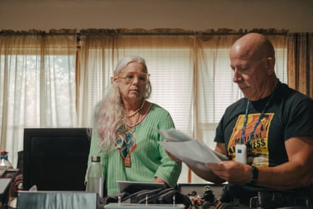 A woman looks at a man holding a stack of papers