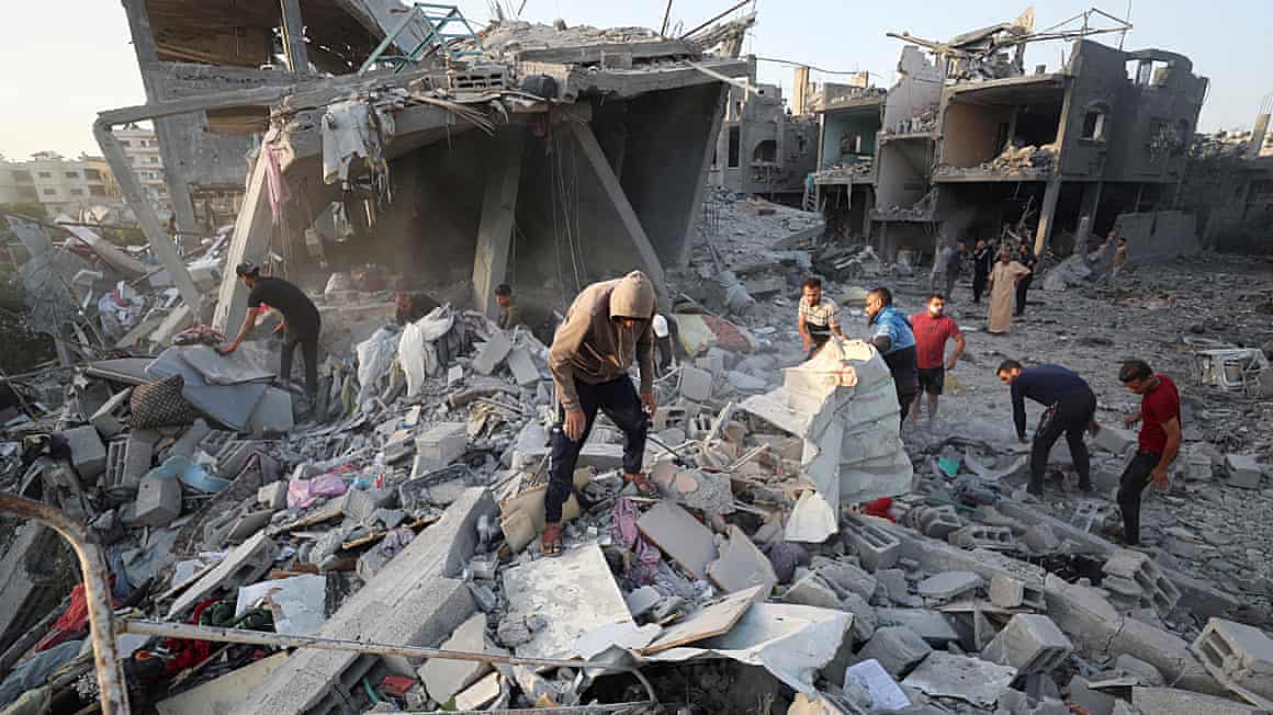 Palestinians examine the rubble of destroyed buildings