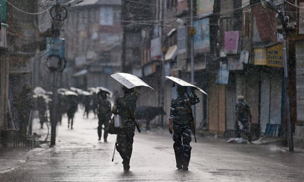 Armed Indian security forces personnel patrol a deserted street in Srinagar August.
