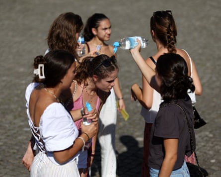 Young girls stand in a group holding bottles of water