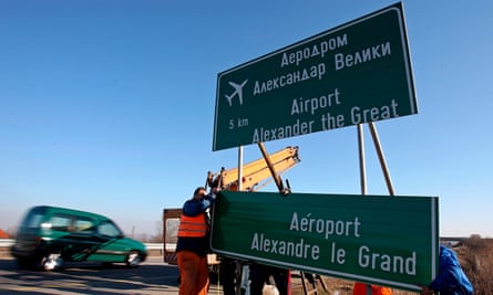 Workers remove a road sign with the former name of Skopje’s airport.