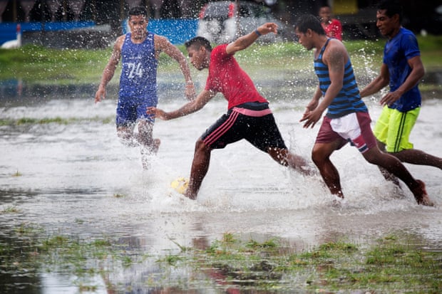A local derby football match played at the main stadium in Bairiki, South Tarawa, on a flooded pitch.