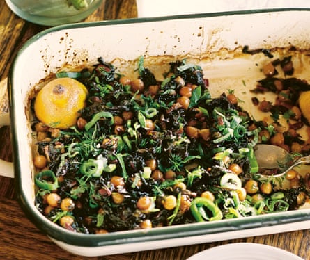 A baking dish filled with chickpeas and green vegetables
