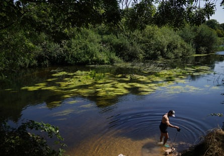 A man takes his dog for a paddle in the River Lea near Hackney Marshes in east London.