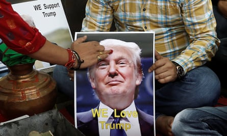 A priest applies a tika on the portrait of Donald Trump during a special prayer to ensure his victory, in New Delhi on Wednesday.