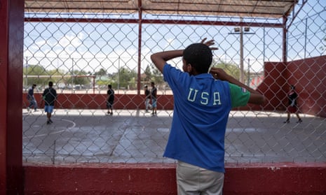 A resident of a migrant shelter watches a soccer match at a nearby park on 9 June.