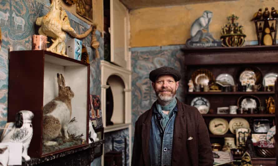 Mark Hearld with a stuffed hare, pottery and mochaware displays.
