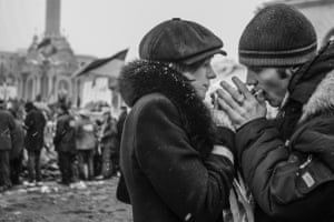Warming one another’s hands in the bitter cold, a couple join fellow demonstrators on the main square in Kyiv