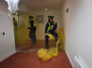 Police officers deal with a flare that was thrown through a window at Old Trafford.