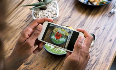 Male hands taking a picture of smoothie bowl with a smartphone
