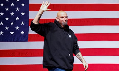 Fetterman waving in front of US flag.