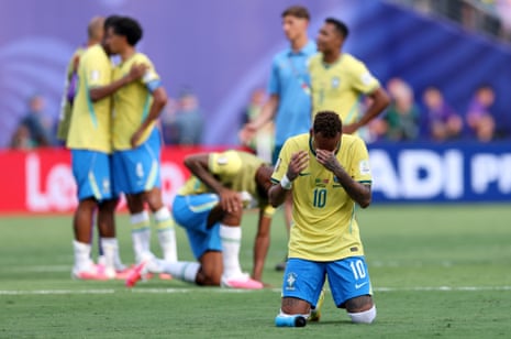 Neymar of Brazil kneels on pitch with his hand to his head
