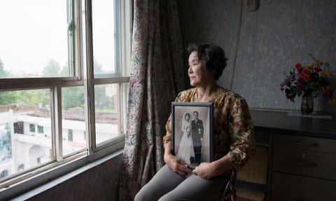 Mitsuko Minakawa, 77, with her wedding
photograph; the couple moved to North Korea
in 1960.