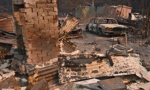 A vintage Jaguar car sits in ruins after a bushfire destroyed a property in Old Bar, NSW
