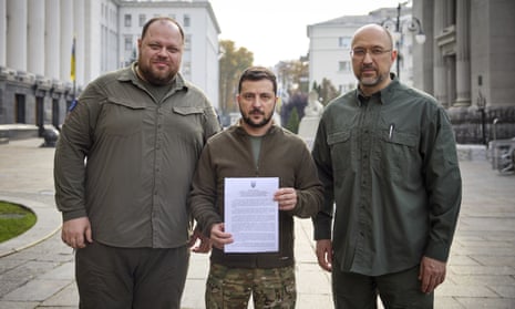 Ukrainian President Volodymyr Zelenskiy holds an application for '‘accelerated accession to NATO'’ in Kyiv, Ukraine.