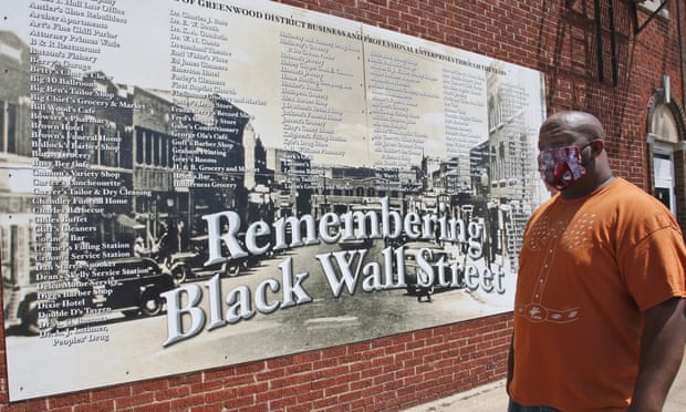 Freeman Culver looks at a mural listing the names of businesses destroyed during the 1921 Tulsa Race Massacre.