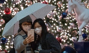 People pose for a selfie in front of a Christmas Tree on Boxing Day at Tai Kwun in Hong Kong’s Central district.