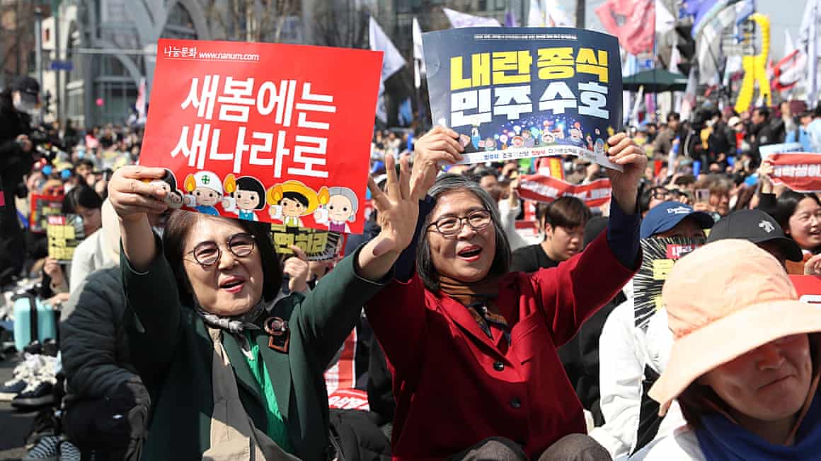 Crowds of people holding up signs