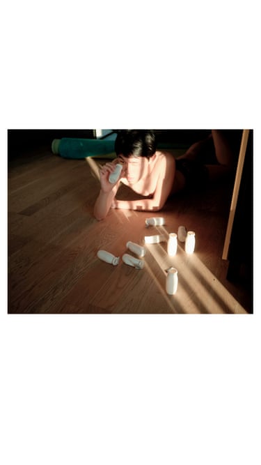 A man on the floor looking through yoghurt bottles