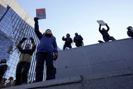 People hold up signs at protest