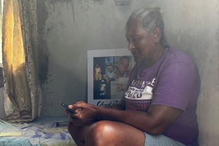 a woman sits and looks at her phone
