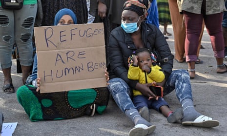 refugees with placard 'Refugees are human beings'