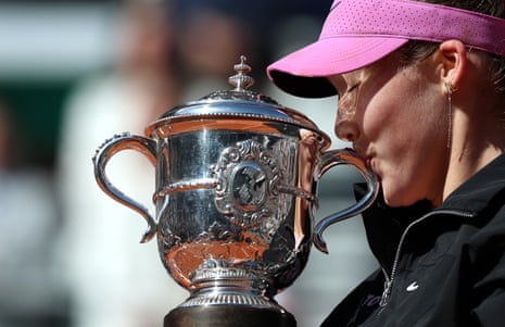Mirra Andreeva kisses La Coupe Suzanne-Lenglen as she celebrates her victory.