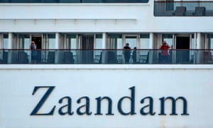 Passengers use binoculars onboard Holland America’s cruise ship Zaandam as it entered the Panama City bay to be assisted by the Rotterdam cruise ship with supplies, personnel and Covid-19 testing devices, eight milles off the coast of Panama City, 27 March, 2020.