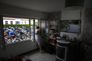 A woman cheers the riders as she stands at her window during the fourth stage, which started in Dunkirk and finished in Calais, France
