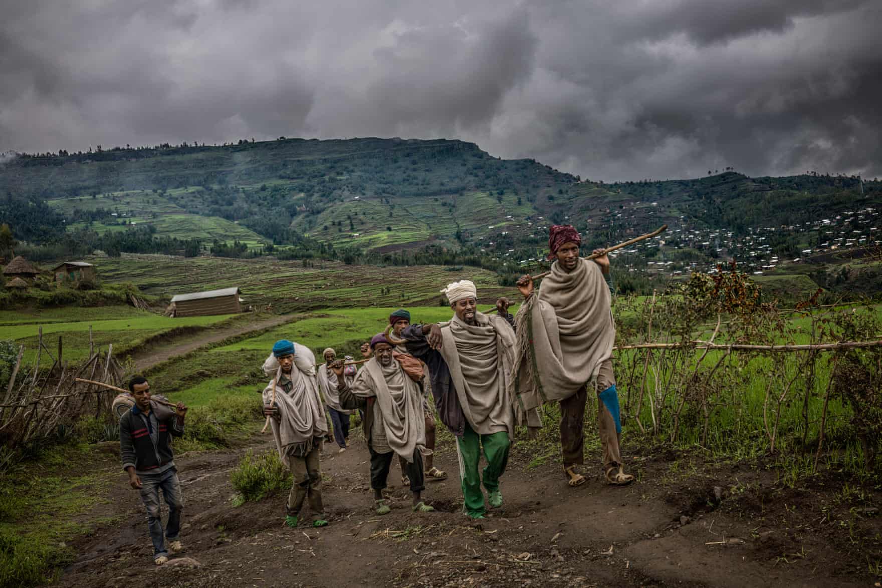 A group of men walk back to their village. Walking is the most common mode of transport in the highlands, where there are few motorbikes and people often have to cross difficult terrain to reach the nearest town via The Guardian