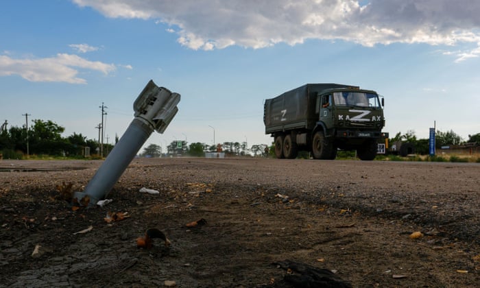 A Russian military truck drives past an unexploded munition in the village of Chornobaivka, Kherson region, Ukraine.