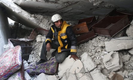 Samir Salim, a members of the White Helmets rescue service, sits in the rubble of his home in the town of Medeira in eastern Ghouta.