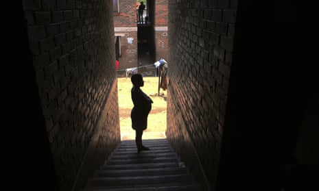 A pregnant woman waits in a passageway