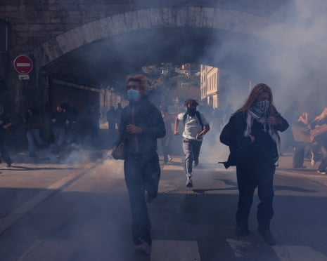 Demonstrators run from tear gas during student protests in Lyon, eastern France.
