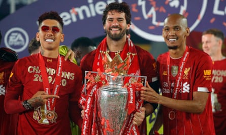 Liverpool’s Roberto Firmino, Alisson and Fabinho pose with the Premier League trophy.