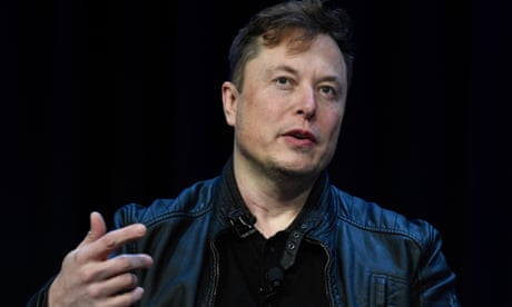 A man wearing a leather jacket gestures while speaking