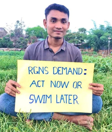 A young man holds a sign saying RGN demand: act now or swim later