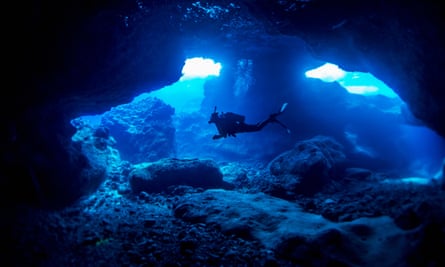a scuba diver swimming through a cave 