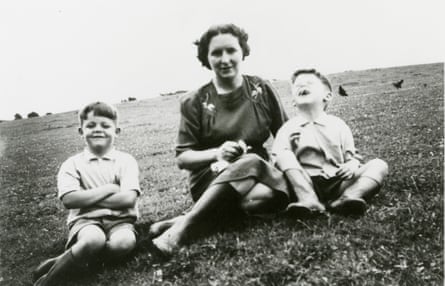 Two boys with their mother sitting on the grass