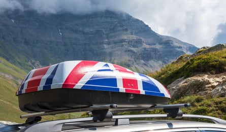 SUV with roof baggage trunk in colours of UK flag in French Alps