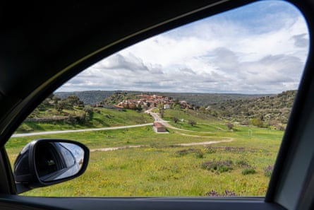 A small hilltop village seen through the window of a car