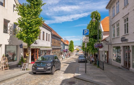 BMW i3 electric hatchback driving over the Norwegian cobbled shopping street in Stavanger, Norway