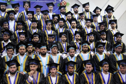 Rows of glum young Afghan men in mortarboards and gowns