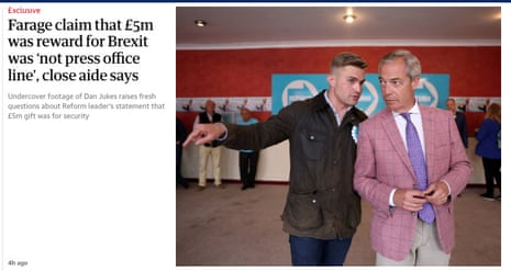 An aide points while speaking to Nigel Farage, in a pink checked blazer, indoors