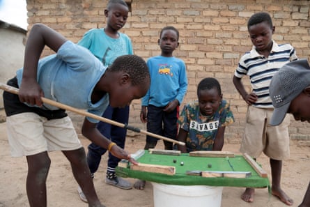 Children play on a makeshift pool table, Hopley, Harare