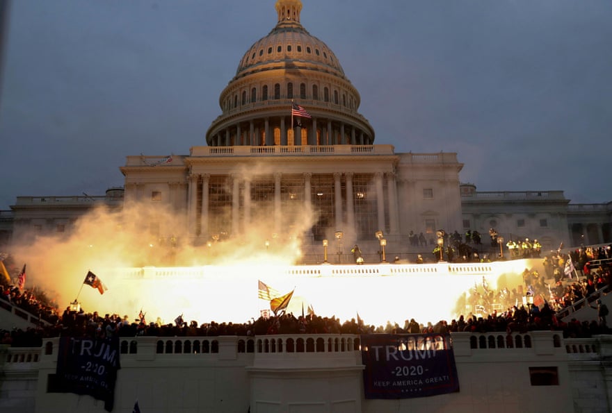 An explosion caused by a police munition is seen as Trump supporters attack the US Capitol on 6 January 2021.